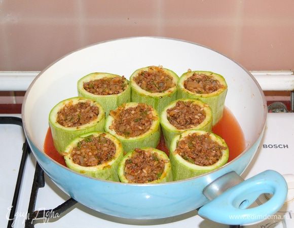 Кабачки перед фаршировкой немного солим, потом наполняем фаршем и складываем в глубокую сковороду. Добавляем в сковороду соус из воды и томатной пасты или помидор с солью. Жидкости достаточно влить до середины кабачков. Внутрь кабачков наливать не надо. Сверху сбрызгиваем оливковым масло и тушим под крышкой.