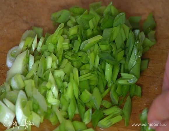 Зеленый лук порезать мелко наискосок.