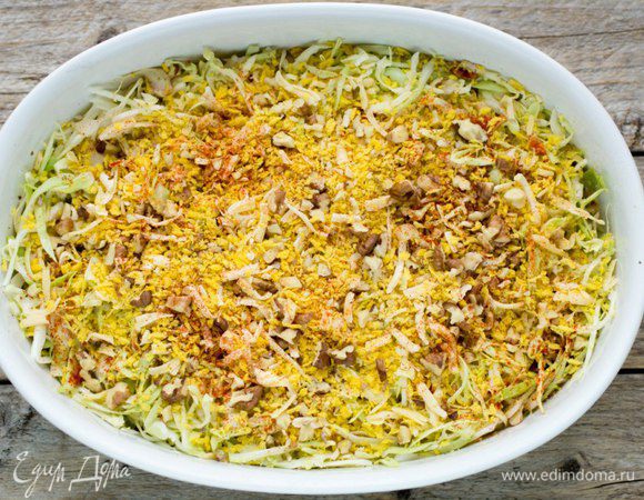 Залить капусту молоком, сверху посыпать хрустящей смесью и отправить в предварительно разогретую до 180 градусов духовку на 15 минут. 
Если готовить из немолодой капусты, время увеличить до 30 минут.