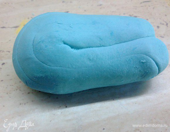 Замесить мастику. 
Рецепт 100 гр. маршмелоу 1ст л. слив. масла поставить в свч на 30 сек, потом постепенно добавлять 250- гр сахарной пудры и вымешивать массу, до того, как она начнет отлипать от рук. Положить готовую массу в холодильник на пару часов. Достать из холодильника и еще раз размять до комнатной температуры. Работая с мастикой посыпайте стол и руки крахмалом. Добавить голубой краситель и снова вымесить до однородности цвета.