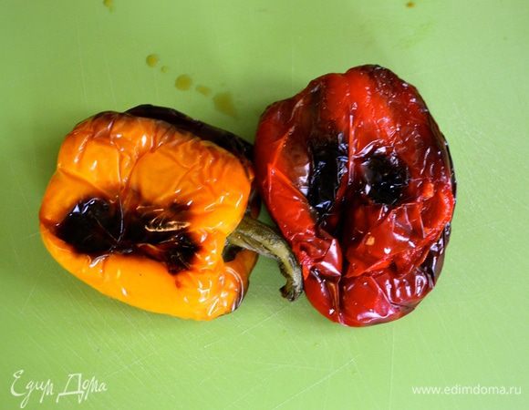 Болгарские перцы вымыть, выложить на противень и запечь в разогретой до 200°C духовке до приобретения ими "подпалин" (минут 30). Перцы достать из духовки, выложить в пакет и дать им остыть.