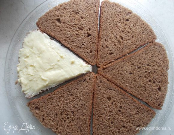 Каждый кусочек хлеба смазываем плавленным сыром.