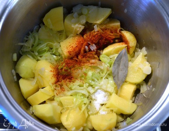 Затем добавить картофель, специи и лавровый лист. Посолить и залить горячей водой. Варить всё 30-35 минут до готовности картофеля.