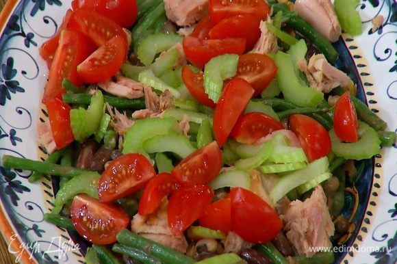На салат выложить кусочки тунца, посыпать порезанными помидорами и сельдереем.