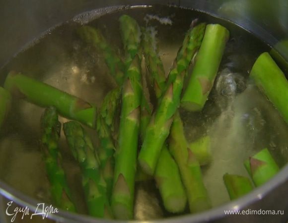 Спаржу, удалив грубые черенки, разрезать на две части и бланшировать в кипящей воде, так чтобы она осталась слегка хрустящей, затем выложить на тарелку.