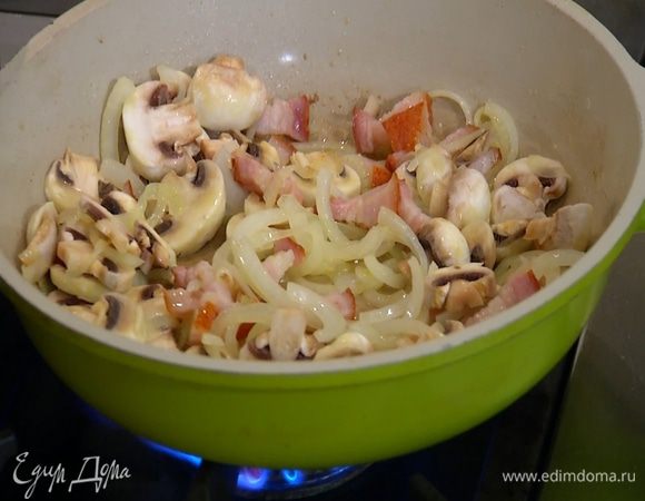 Шампиньоны нарезать пластинками, добавить в сковороду, все поперчить и перемешать.