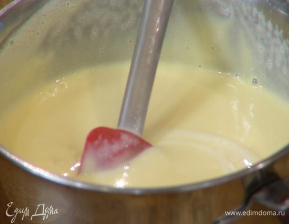 Продолжая взбивать, небольшими порциями влить половину горячего молока, затем перелить яично-молочную смесь в кастрюлю с оставшимся молоком и поместить ее на огонь. Непрерывно помешивая, уваривать крем 5–7 минут на медленном огне, чтобы он загустел.