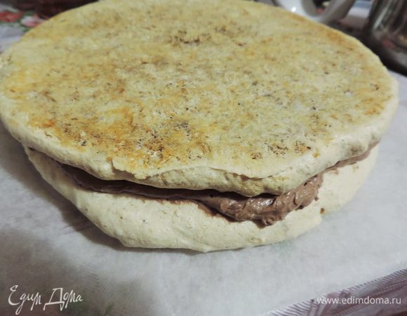 Остывший коржи промазываем подготовленным кремом. Обратите внимание, что второй корж мы кладем вверх той стороной, на которой он выпекался, чтобы верх у торта был ровным.
Убираем заготовку в холодильник.