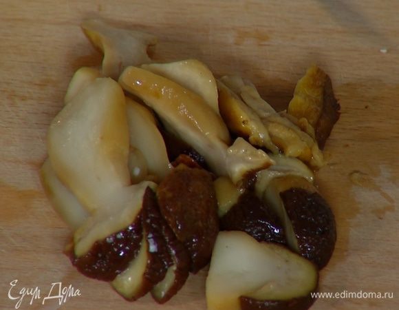 Белые грибы нарезать вдоль пластинками, выложить в сковороду с луком и чесноком, посолить, поперчить.