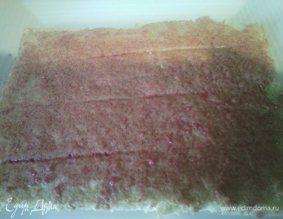 Отделить корж от пекарской бумаги, разрезать пополам, сказать сиропом, выложить немного крема, сверху прослойка из киви (отделите аккуратно от тарелки, пройдясь тонким ножом).