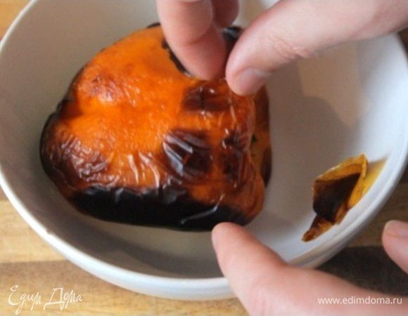 Запекаем сладкий перец под грилем до черноты. Далее кладем его в тарелку и накрываем пищевой пленкой, чтобы отстала кожура. Спустя 5 минут снимаем с перца кожуру.