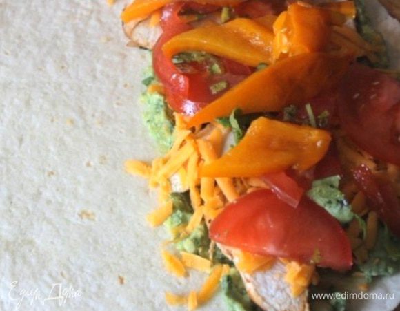 Собираем кесадилью. На половину тортильи укладываем по порядку: гуакамоле, куриные грудки, сыр чеддер, помидоры с кинзой, полоски печеного перца.