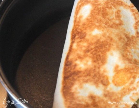 Накрываем начинку второй половиной тортильи и обжариваем на сухой сковороде с обеих сторон до золотистости.