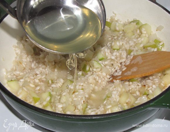 Добавить половник горячего бульона и постоянно помешивать, пока бульон не впитается. Тогда вливать следующую порцию бульона. Варить ризотто 17 минут, помешивая и подливая бульон (его может понадобиться чуть меньше или больше в зависимости от риса). Крышкой ризотто не закрывать. 
