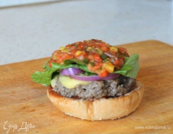 Поверх сыра кладем кусочки маринованого чили перца. Далее луковые кольца, листья салата и манговую сальсу.