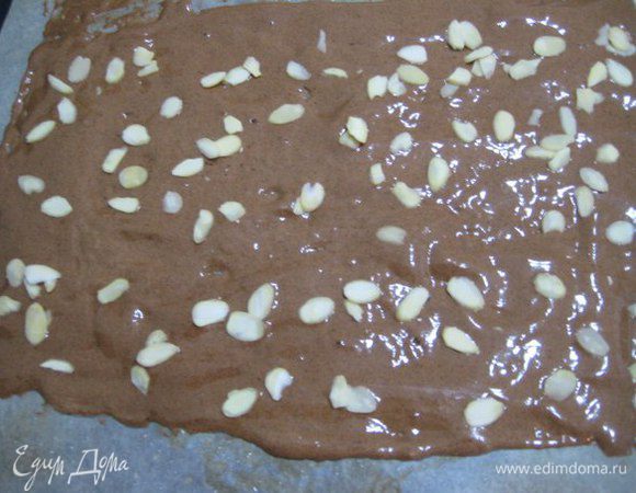 Аккуратно вмешать смесь просеянной муки и какао-порошка. Вылить тесто на противень, разровнять до толщины 0,5 см. Сверху посыпать лепестками миндаля. Выпекать 6-8 минут.