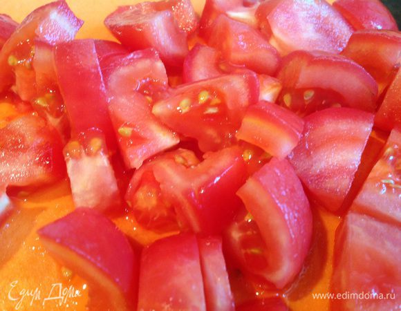 У помидоров сделайте надрез, залейте кипятком на 1-2 минуты, после чего окуните в холодную воду и снимите кожицу. Помидоры нарежьте кубиками.