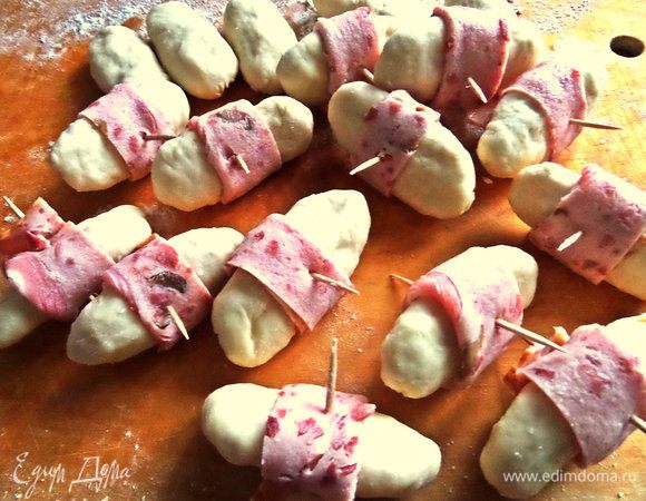 Бекон или ветчину нарезать на полоски и обернуть каждый пирожок, скрепить зубочистками.