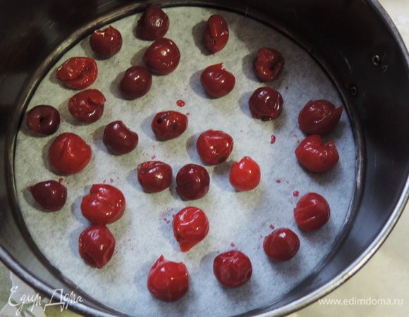 Перед приготовлением бисквита, отмериваем и отцеживаем через ситечко нужное количество "пьяной" вишни, я указываю вес уже сухой вишни.
Форму диаметром 18 см выстилаем бумагой для выпечки, равномерно распределяем сверху вишню.
