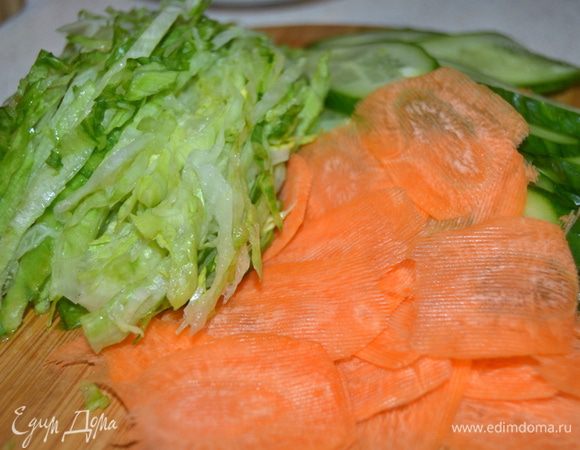 Огурец нарезать тонкими ломтиками, салат нашинковать (салат можно заменить на пекинскую капусту), морковь нарезать тонкими пластинами, удобно это сделать овощечисткой.