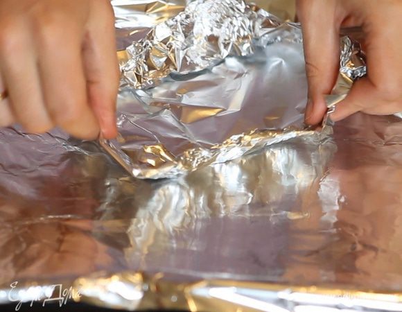 Застилаем противень фольгой. Формируем из отрезков фольги мисочки по размеру нарезанных стейков трески.