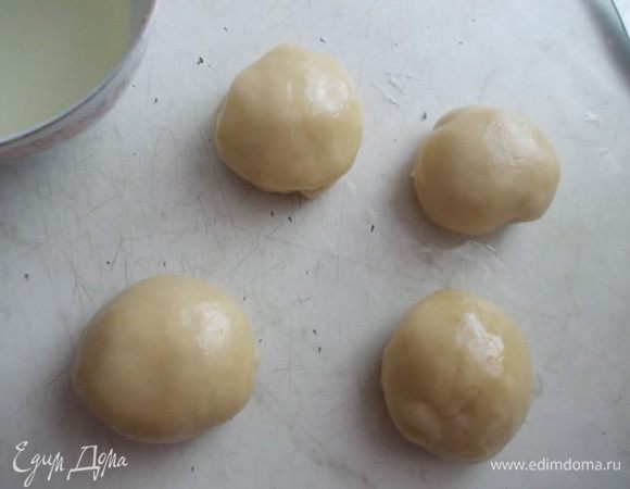 По прошествии 20 минут, достать тесто, разделить его на 4 части. Каждую скатать в шарик и смазать маслом.