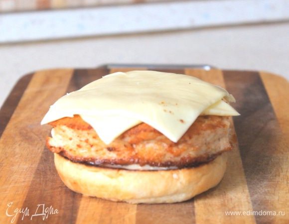 Собираем наш бургер. Обжарив булку, намазываем майонез, кладем куриную котлету и сыр пластинками. 