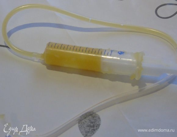 Подготовьте миску с очень холодной водой. С помощью шприца заполните трубочку от капельницы апельсиновым гелем.