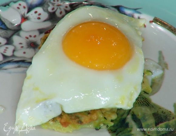 На готовые оладушки разложить карамелизированный лук и жареные яйца.