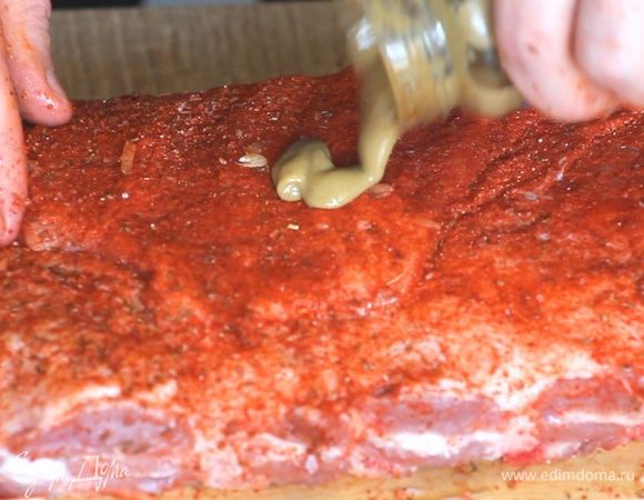 Натираем специями весь кусок ребер. Смазываем горчицей и покрываем ребра нарезанным луком и чесноком. Горчица здесь также играет роль клея.