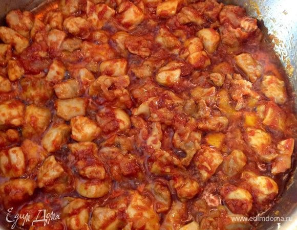 Когда жидкости почти не останется, а на дне под мясом будет только масло, добавить томатную пасту (можно пополам с пастой из сладкого красного перца). Хорошо перемешать, продолжая жарить еще минуты 3-4. Мясо станет однотонным по цвету, а томатная паста немного потемнеет. 