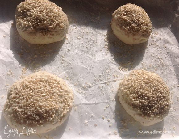 Делим тесто на примерно одинаковые кусочки, выкатываем руками колобок, кладем на пергаментную бумагу, посыпанную мукой, посыпаем их кунжутом и выпекаем 20-25 мин на 190 градусов.