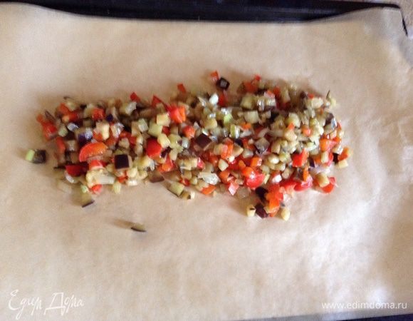 Положить лист фольги, сверху лист пергамента, на пергамент положить рыбу, сверху выложить овощи.