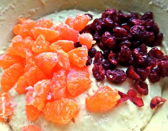 Высыпать в тесто вместе с клюквой и цедрой.