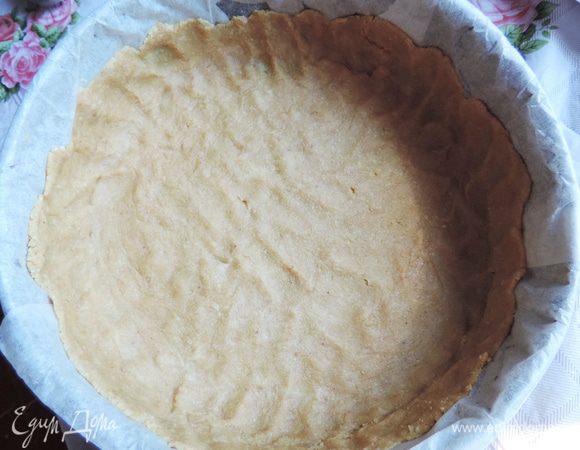 Берем разъемную форму диаметром 22 см. Дно и бока выстилаем бумагой для выпечки. Полученную сливочную массу равномерно распределяем по дну и бокам, формируя бортики высотой примерно 2,5 см. Тщательно утрамбовываем. Слой получается тоненьким.
Убираем форму в холодильник на время приготовления начинки.