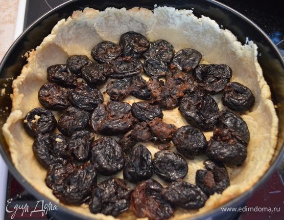 На слегка запеченное тесто выкладываем по кругу чернослив.