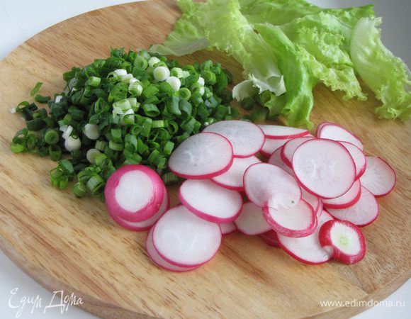 Зеленый лук очень мелко нарезать. Редис нарезать очень тонкими кружками. Листья салата нарвать небольшими кусочками.