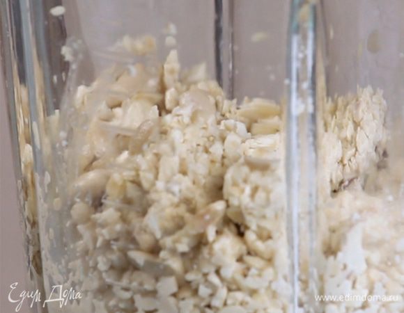 В чашу блендера сложить кешью и чеснок, перемолоть в гладкую массу, постепенно добавляя воды.