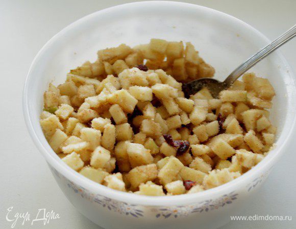 Яблоки очистите от кожуры и семечек, нарежьте кубиками, смешайте их с клюквой, сахаром, корицей и панировочными сухарями.