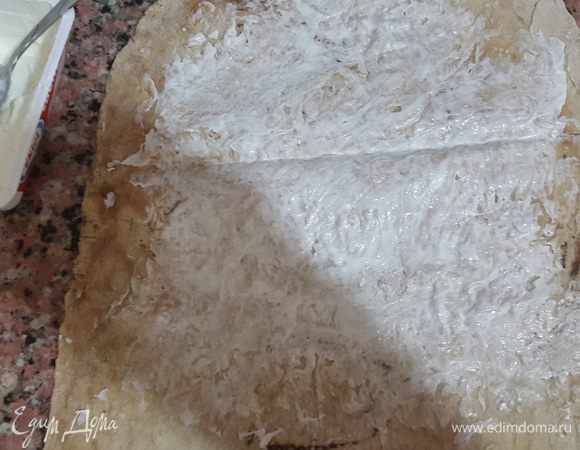 Лаваш разрезаем на две части и тонким слоем смазываем мягким сыром не захватывая края. У меня был сыр лабне.