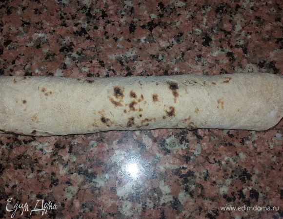 Аккуратно сворачиваем лаваш подгибая нижний край.