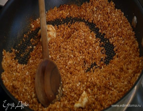 Чеснок почистить, раздавить плоской стороной ножа, добавить в сковороду с сухарями, перемешать и обжаривать 1–2 минуты, затем чеснок удалить.