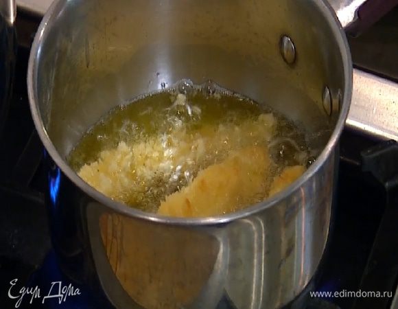 В небольшую кастрюлю налить оливковое масло слоем в два сантиметра, разогреть его и жарить рыбу до готовности.