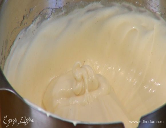 Продолжая взбивать на средней скорости, частями влить желтки с молоком и еще немного вымешать.