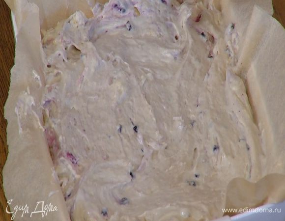 Керамическую жаропрочную форму выстелить бумагой для выпечки, выложить тесто и разровнять его.