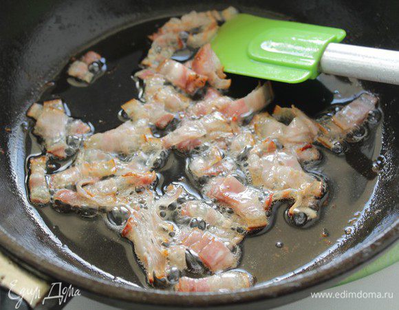 Уменьшаем огонь до среднего, кладем в сотейник мелконарезанный бекон и жарим, помешивая, 2-3 минуты.