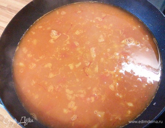 На этом этапе добавляем помидоры, паприку и шафран вместе с водой. Влейте  горячий овощной (или куриный) бульон, дайте закипеть и варите  без крышки около 10 мин. 