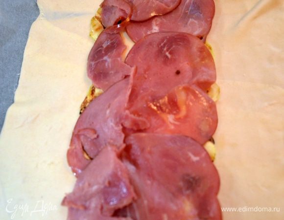 Разложить тесто на пекарской бумаге, в середину положить слой кабачков. Сверху сыр.
Сверху ветчину. Если остались кабачки, можно сделать сверху еще один слой.