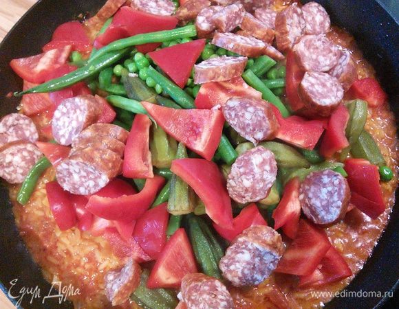 Когда основная жидкость впитается, добавляем овощи, колбаски маслины. 