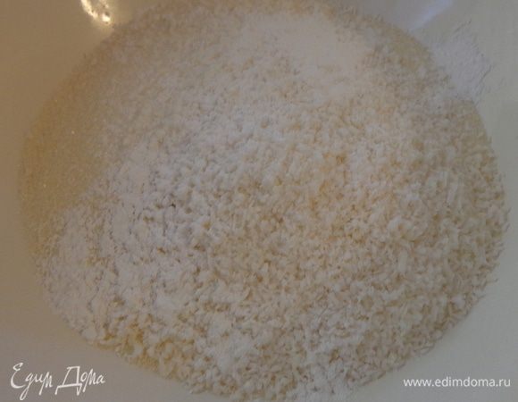 Смешать в миске все сухие ингредиенты: сахар, манку, кокосовую стружку и разрыхлитель.